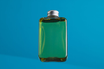 Beauty product glass bottle with copy space on blue background