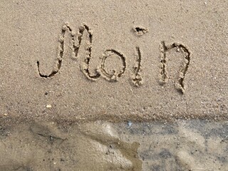 Moin als Gruß in den Sand geschrieben am Strand der Nordsee in Cuxhaven