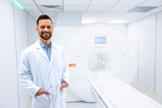 Portrait of smiling doctor radiologist standing inside hospital MRI diagnostic center.