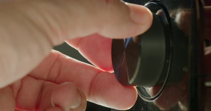 A man's hand adjusts the volume level, turns the knob on the receiver