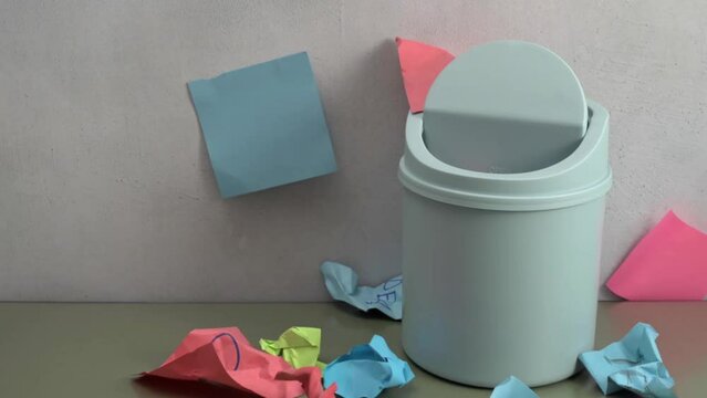 Crumpled multicolored sheets of notes are thrown into the trash. Search for a creative idea metaphor