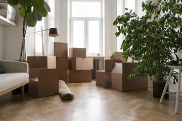 Empty living room with stacked cardboard boxes with personal belongings on relocation day, prepare...
