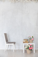 gray chair coffee table with books and flowers in a bright room