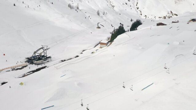 Drone, ski and lift on mountain range with snow in Switzerland for travel, adventure or holiday. Swiss alps, gandola and activity in winter with fresh air, nature and people on slope with snowboard