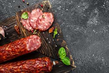 Traditional slice salami sausage with spices on a wooden board. banner, menu, recipe place for...