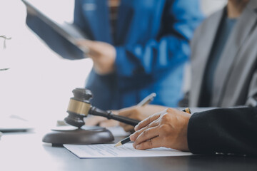 Business and lawyers discussing contract papers with brass scale on desk in office. Law, legal services, advice, justice and law concept picture with film grain effect