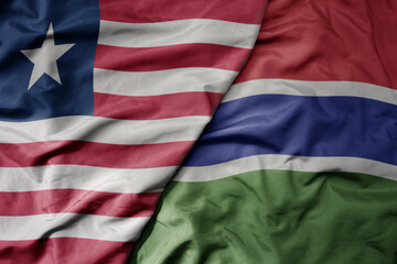 big waving national colorful flag of gambia and national flag of liberia .