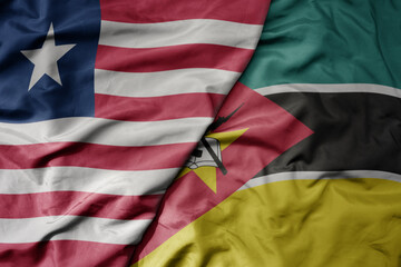 big waving national colorful flag of mozambique and national flag of liberia .