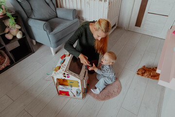 Mom and baby boy playing on the floor in construction set