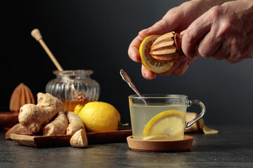Ginger tea with lemon and honey on a black background.