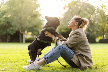 Blonde girl of forty years old cuddles with her dog