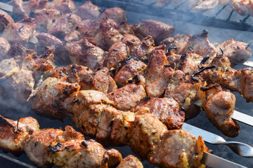Pork meat is fried on smoking coals in the grill