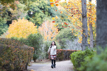 秋の公園を散歩する女の子