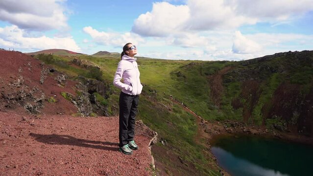 Tourist girl looks at the crater of a volcano
