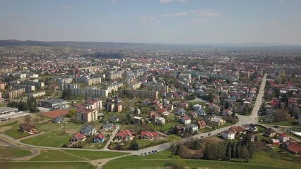 Panorama from a bird's eye view. Central Europe: The Polish village is located among the green hills and river. Temperate climate. Flight drones or quadrocopter. Urbanization of the landscape.