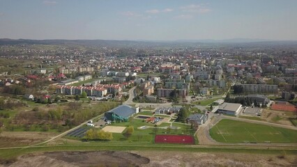 Fototapeta na wymiar Panorama from a bird's eye view. Central Europe: The Polish village is located among the green hills and river. Temperate climate. Flight drones or quadrocopter. Urbanization of the landscape.
