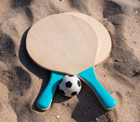 Beach ball rackets and a ball on a beach sand - 680130577