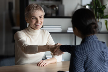 New hired employee and recruiter shaking hands after successful interview. Employer hiring candidate, welcome to team. Business partners giving handshake in office after negotiations, closing deal.