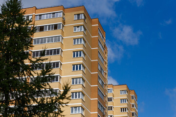 new high rise brick apartment buildings with spruce tree