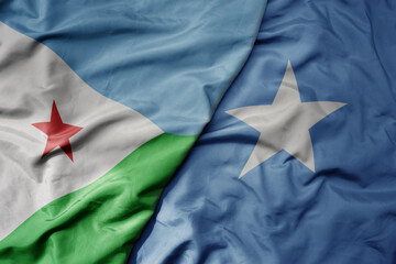 big waving national colorful flag of somalia and national flag of djibouti .