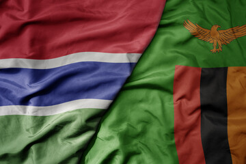 big waving national colorful flag of zambia and national flag of gambia .