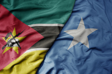 big waving national colorful flag of somalia and national flag of mozambique .