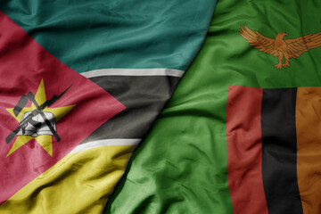 big waving national colorful flag of zambia and national flag of mozambique .
