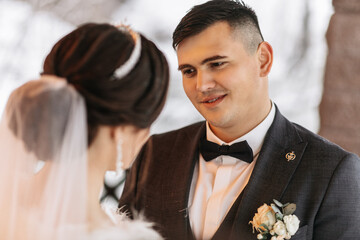 Beautiful wedding couple. Winter wedding of the groom in a beautiful suit and the bride in a...
