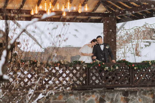 Beautiful wedding couple. Winter wedding of the groom in a beautiful suit and the bride in a beautiful wedding dress. Winter photo shoot newlyweds.