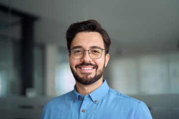 Smiling happy young latin business man bank manager, adult professional businessman executive in office, male entrepreneur, software developer or company employee wearing glasses, headshot portrait. - Powered by Adobe