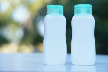 Two bottles of body lotion containers. Outdoor background . Concept, Skin care moisture and nourishing skin cosmetic product. Body skin treatment for beauty  and healthy.     