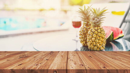 blur tropical fruit drink on pool side table in beach hotel resort with blank wooden counter for...