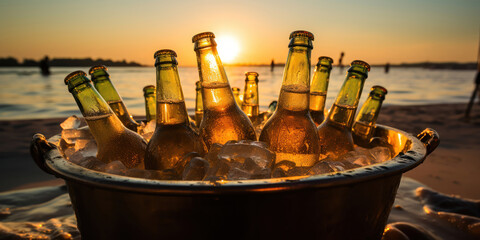 Chilled beer bottles in an ice bucket on a sunset beach