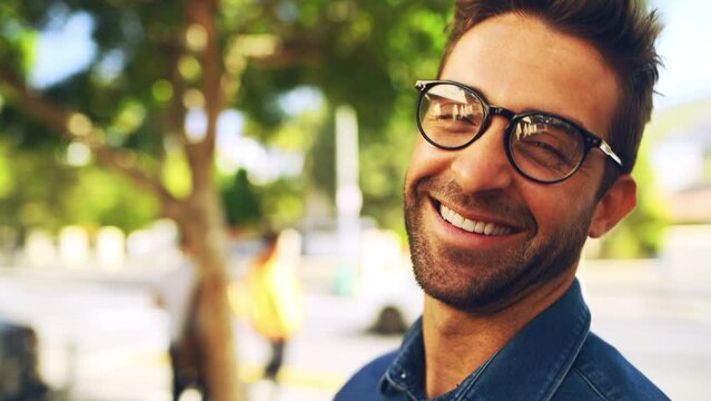 Man, face and happy outdoor in street with casual style, trendy outfit and glasses in urban town or city. Person, portrait and smile with confidence, pride and joyful expression in nature or summer