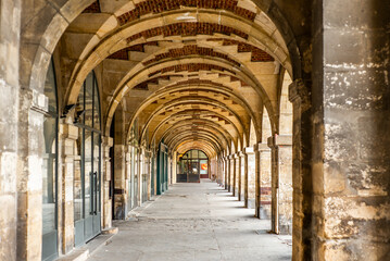 Fototapeta na wymiar The arcade in the Place des Vosges in Paris