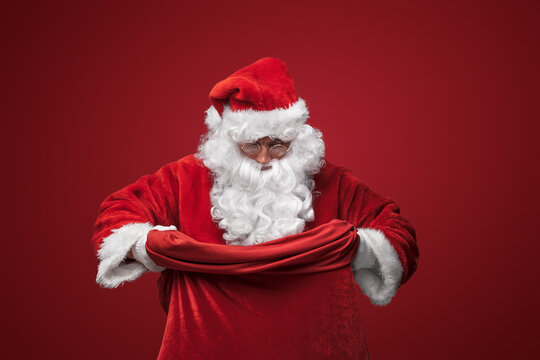 Santa Claus in his classic red suit, confidently holding a bag
