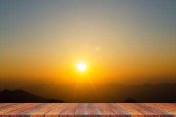 Fototapeta na wymiar Wood table top on blur tropical scene of sunset or sunrise on the mountain in the summer with a yellow-blue sky background - can be used for display or montage your products. High quality photo