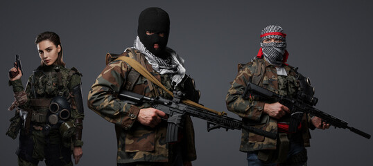Trio of radical extremists from the Middle East in camo attire, keffiyeh, and balaclava, striking a...