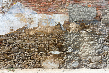 Setubal, Portugal. 10 August 2023. Closeup pattern of surface brick wall concrete plaster for vintage background. Colors ocher, white, grey and red. Wall texture for background. damaged to wall textur