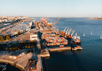 Aerial photo of scenic view of big cargo container ship loading Lisbon (Portugal) on sunset. Port...