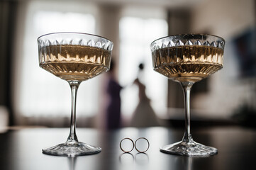 two martini glasses and wedding rings