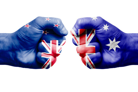 NEW ZEALAND vs AUSTRALIA confrontation, religious conflict. Men's fists with painted flags of NEW ZEALAND and AUSTRALIA.