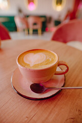 A cup of cappuccino on the table in a pink cafe - 680177746