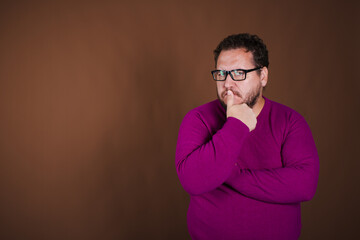 Obraz premium Funny fat man posing in studio on brown background. Different emotions.