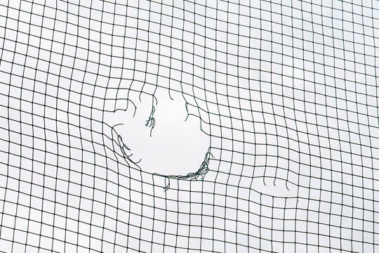 Soccer ball breaking net. Concept of football goal. Close Up of a Soccer Goal Net.