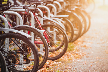 Bikes of different styles and colors lined up in a parking lot in the urban streets of a European destination for tourists and cyclists.