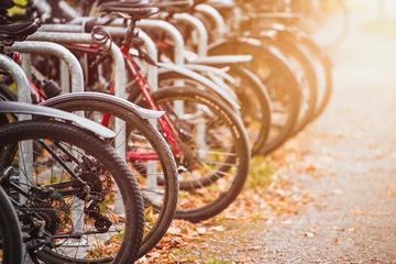  Bikes of different styles and colors lined up in a parking lot in the urban streets of a European destination for tourists and cyclists. © AlexGo