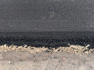 Close-Up Texture of Fresh Hot Asphalt on a New Road. Road Construction. Layers of Fresh Hot Asphalt Texture