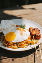 Scrambled eggs with rice on a white plate. Asian rice with sauce on the table