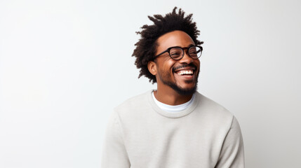 A beaming Black man with glasses, photographed against a simple white background. - obrazy, fototapety, plakaty